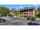Multi-story building with wooden balconies and a parking lot with several cars parked in spaces at 223 Maison Dr. # 14D, Myrtle Beach, SC 29572