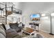 Cozy living room with comfortable gray sofa, decorative pillows, a spiral staircase and a beach view on TV at 223 Maison Dr. # 14D, Myrtle Beach, SC 29572