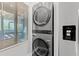 Modern stacked washer and dryer set, next to a stainless steel refrigerator in its own dedicated laundry area at 223 Maison Dr. # C-13, Myrtle Beach, SC 29572
