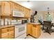 Well-lit kitchen with breakfast area, oak cabinets, and white appliances at 24 Gate 7, Carolina Shores, NC 28467