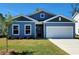 Charming single-story home featuring a blue exterior, manicured lawn, and attached two-car garage at 261 Bolsin Ct, Conway, SC 29526