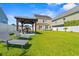 The backyard has a large grassy area, a gazebo with a grill, and lounge chairs for relaxing and entertaining at 309 Foxpath Loop, Myrtle Beach, SC 29588