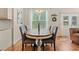 Cozy dining area with a wood table, upholstered chairs, chandelier, and large window at 309 Foxpath Loop, Myrtle Beach, SC 29588