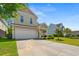 Traditional two-story home featuring a two-car garage, covered front porch, and well-maintained landscaping at 309 Foxpath Loop, Myrtle Beach, SC 29588