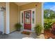 Inviting front entryway with a red door, decorative wreath, sidelights, and potted plants at 309 Foxpath Loop, Myrtle Beach, SC 29588