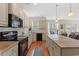 Open kitchen featuring an island, stone countertops, and wood-look floors at 309 Foxpath Loop, Myrtle Beach, SC 29588