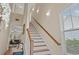 Bright staircase with white risers, wood treads, a wooden handrail, and natural light at 309 Foxpath Loop, Myrtle Beach, SC 29588