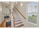 Bright staircase with white risers, wood treads, wooden handrail, window, and wall sconces at 309 Foxpath Loop, Myrtle Beach, SC 29588