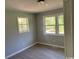 Bedroom with grey walls, vinyl floors, and two windows at 321 Circle Heights Dr., Loris, SC 29569