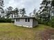 Wide shot of the rear of the home showing the manicured lawn and wooded setting at 321 Circle Heights Dr., Loris, SC 29569