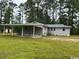 A side view of the home showing a well-maintained yard and attached carport at 321 Circle Heights Dr., Loris, SC 29569