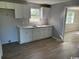 Efficient kitchen featuring white cabinets, wood-look floors, and natural light at 321 Circle Heights Dr., Loris, SC 29569