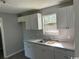 Functional kitchen featuring white cabinets, sink, and wood-look flooring at 321 Circle Heights Dr., Loris, SC 29569