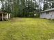 Large backyard with mature trees, lush lawn, and storage shed at 321 Circle Heights Dr., Loris, SC 29569