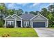 Charming single-story home with green siding, neat landscaping, and a two-car attached garage at 321 Sanctuary Ct., Myrtle Beach, SC 29588