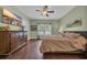 Spacious main bedroom with a ceiling fan, dark wood floors, and large dresser with a large television at 321 Sanctuary Ct., Myrtle Beach, SC 29588