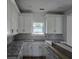 Bright kitchen with white cabinets, granite countertops, and herringbone backsplash, offering a modern design at 3619 Allentown Dr., Conway, SC 29526