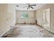Partially renovated room featuring large windows, ceiling fan, and access to another room at 415 42Nd Ave. N, Myrtle Beach, SC 29577