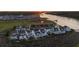 Aerial view showcases a row of waterfront houses with marsh views and a serene river at sunset at 4525 Landing Rd., Little River, SC 29566