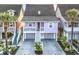 Charming elevated two-story home with a welcoming front porch and landscaped yard with palm trees at 4525 Landing Rd., Little River, SC 29566