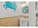 Charming powder room features a vanity, decorative lighting, wainscoting and sea-inspired decor at 4534 Landing Rd., Little River, SC 29566
