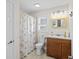 Traditional bathroom with a wooden vanity, seashell themed shower curtain and a bright window at 4534 Landing Rd., Little River, SC 29566