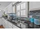 Granite countertops and stainless sink are framed by bright white cabinets and mosaic backsplash at 4534 Landing Rd., Little River, SC 29566