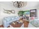 Living room with nautical decor, wood floors, blue sofa and chairs, and a decorative windmill fan at 4534 Landing Rd., Little River, SC 29566