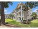 Exterior condo with brick facade, balconies, and lush green space at 4721 Hibiscus Dr. # 3-302, Little River, SC 29566