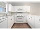 Well-lit kitchen showcasing white cabinets and a sink area under a window, maximizing natural light at 4721 Hibiscus Dr. # 3-302, Little River, SC 29566