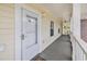 Covered porch entry featuring a white door, light fixture, and tiled flooring at 4721 Hibiscus Dr. # 3-302, Little River, SC 29566