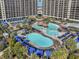 Stunning aerial view of multiple pools with cabanas and lounge chairs, surrounded by high-rise condo buildings at 4901 N Market St., North Myrtle Beach, SC 29582