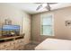 Cozy bedroom featuring a ceiling fan, a dresser with TV, and light beige walls at 4901 N Market St., North Myrtle Beach, SC 29582