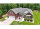 Aerial view of a charming red brick home featuring a well-manicured lawn and a two-car garage at 499 Trestle Way, Conway, SC 29526