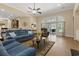 Bright and airy living room with a comfortable blue sofa, ceiling fan, and sliding glass doors to the patio at 499 Trestle Way, Conway, SC 29526