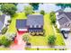 Aerial view of house with a red driveway, lush landscaping, and garage, in a well-maintained neighborhood at 5096 Capulet Circle, Myrtle Beach, SC 29588