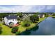 Waterfront property with well-kept lawns, showcasing a glimpse of the lake and the home's backyard at 5096 Capulet Circle, Myrtle Beach, SC 29588