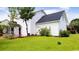 Expansive backyard with lush green lawn, a small patio, and a serene, private setting with well-maintained landscaping at 5096 Capulet Circle, Myrtle Beach, SC 29588