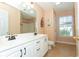 Well-lit bathroom with white vanity, double sinks, and a window providing natural light at 5096 Capulet Circle, Myrtle Beach, SC 29588