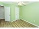 Green bedroom featuring wood-look floors, a ceiling fan, and white trim at 5096 Capulet Circle, Myrtle Beach, SC 29588