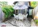 Charming backyard patio features an umbrella-covered dining set, surrounded by lush greenery for serene outdoor living at 514 Blockade Dr., Pawleys Island, SC 29585