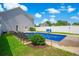 Beautiful backyard pool with ample seating, set against a backdrop of lush greenery and a white fence at 547 Pacific Commons Dr., Surfside Beach, SC 29575