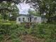 Exterior shot of a weathered home with a wooden porch and an overgrown front yard at 564 Baker Ave., Murrells Inlet, SC 29576