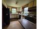 Traditional kitchen with white cabinets, wood trim, black appliances, and worn hardwood floors at 564 Baker Ave., Murrells Inlet, SC 29576