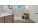 The shower is the focal point in this bathroom with gray cabinets and wood-look flooring at 598 Cascade Loop, Little River, SC 29566