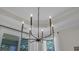 Modern chandelier in a dining room with natural light streaming through the windows at 598 Cascade Loop, Little River, SC 29566
