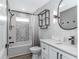 Beautiful bathroom featuring gray wall color, tub with shower, and modern vanity with a framed circular mirror at 6001- Q10 S Kings Hwy., Myrtle Beach, SC 29575