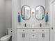 Bright bathroom with dual sinks, white cabinetry, quartz countertops, and framed oval mirrors at 6001- Q10 S Kings Hwy., Myrtle Beach, SC 29575