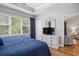 Bedroom features a large window, wood floors, a chest of drawers, TV, and a view into a sitting area at 6015 Catalina Dr. # 634, North Myrtle Beach, SC 29582