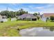 Lush backyard with white fence, mature trees, and a covered patio with a grill, perfect for outdoor living at 605 Fieldwoods Dr., Conway, SC 29526